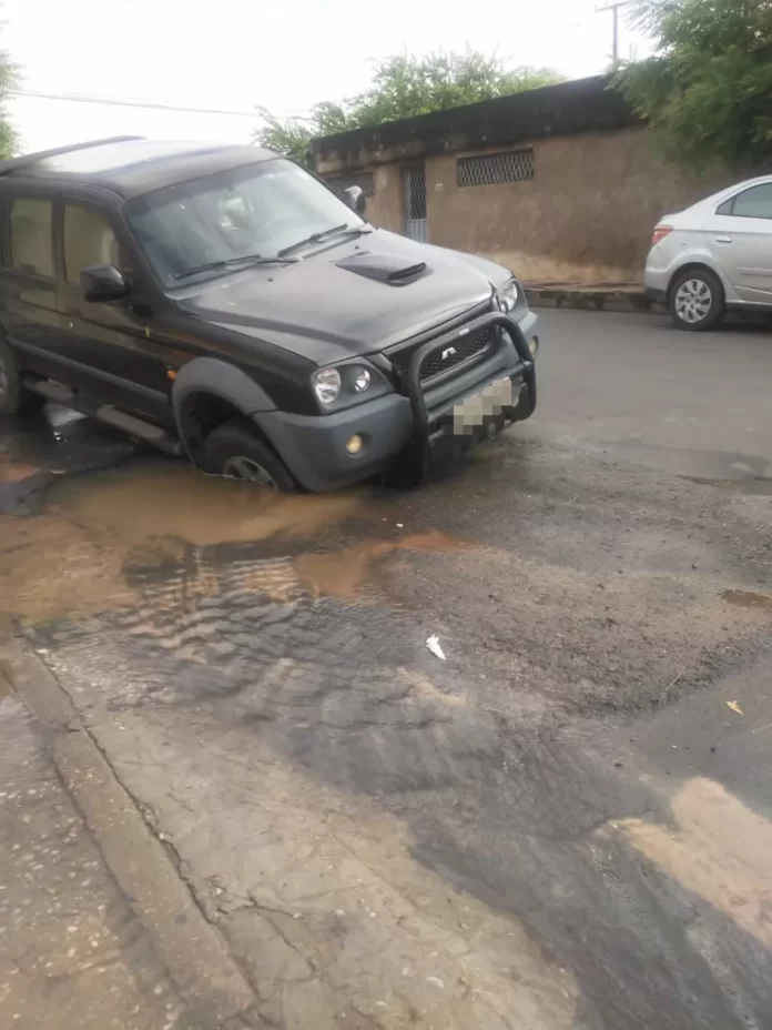 Caminhonete fica presa em cratera após vazamento de água